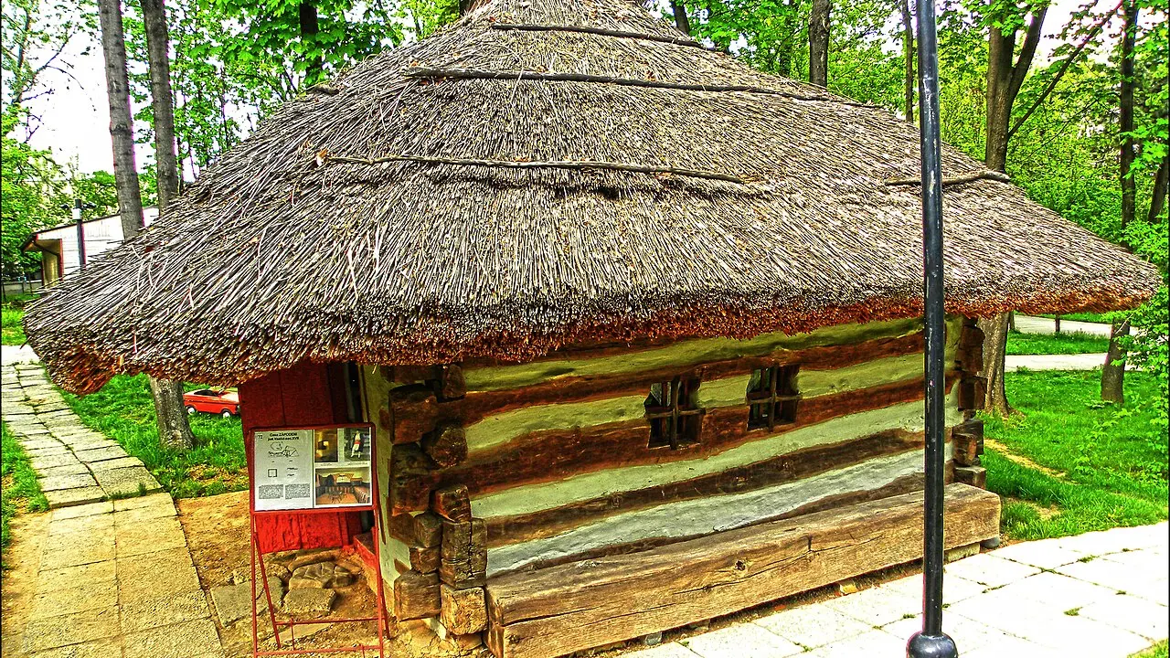 Casă țărănească de lemn cu acoperiș de stuf, expusă în muzeul satului