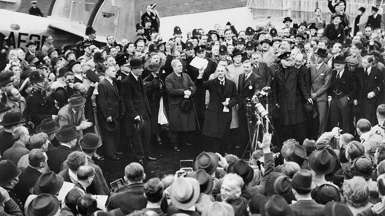 Neville Chamberlain arată o foaie de hârtie unei mulțimi, pe aerodromul Heston, în 1938