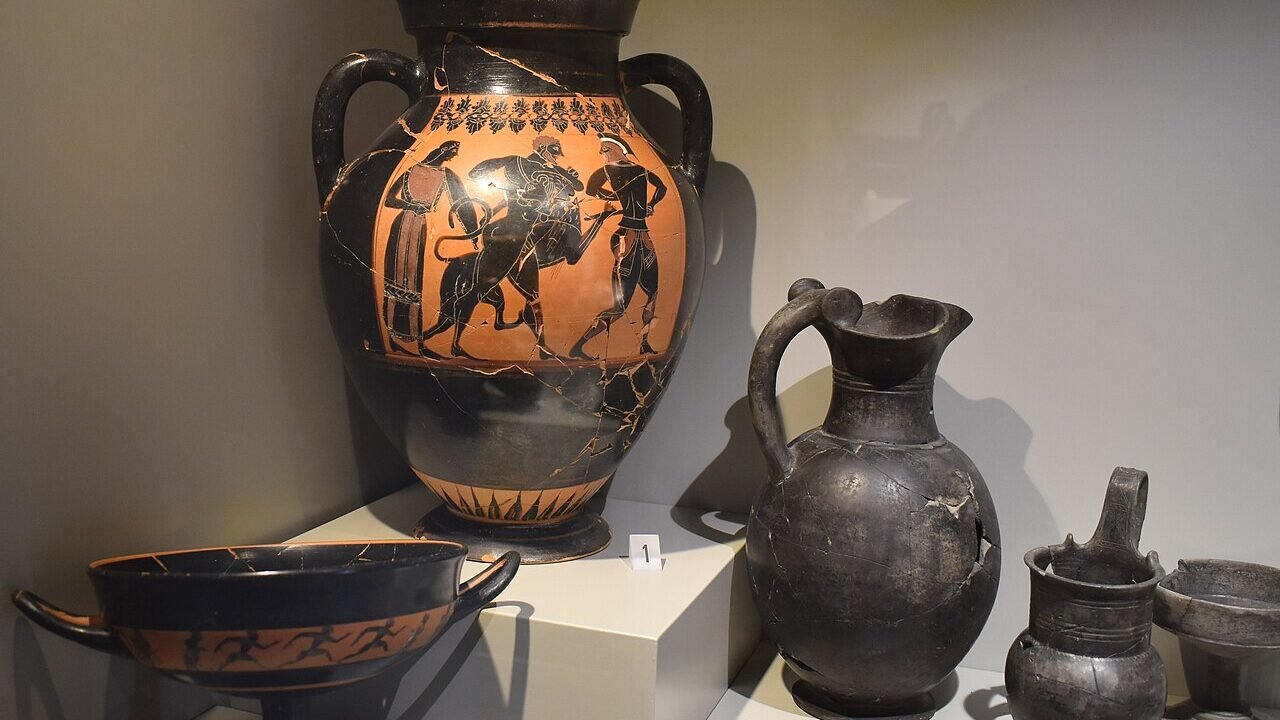 Vitrină de muzeu cu vase și obiecte dintr-un inventar funerar etrusc descoperit la Vulci