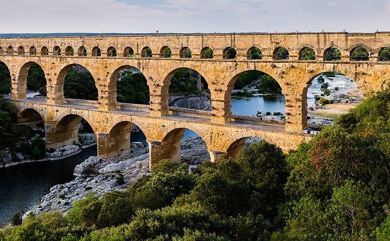 Podul roman Pont du Gard, cu trei rânduri de arcade suprapuse, traversând râul Gardon