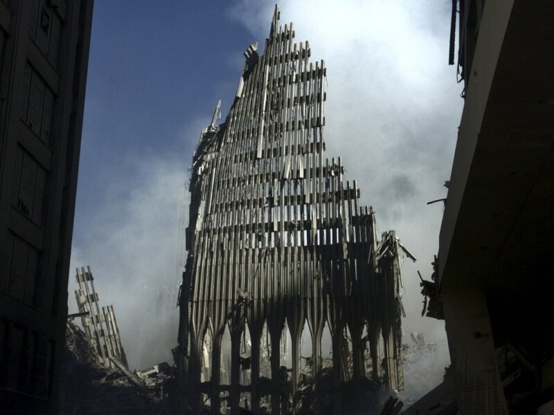 Structura metalică rămasă din turnul sudic al World Trade Center, printre fum și dărâmături, la New York