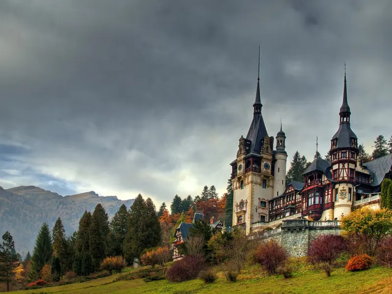 Castelul Peleș de la Sinaia, toamna, cu Munții Bucegi în fundal