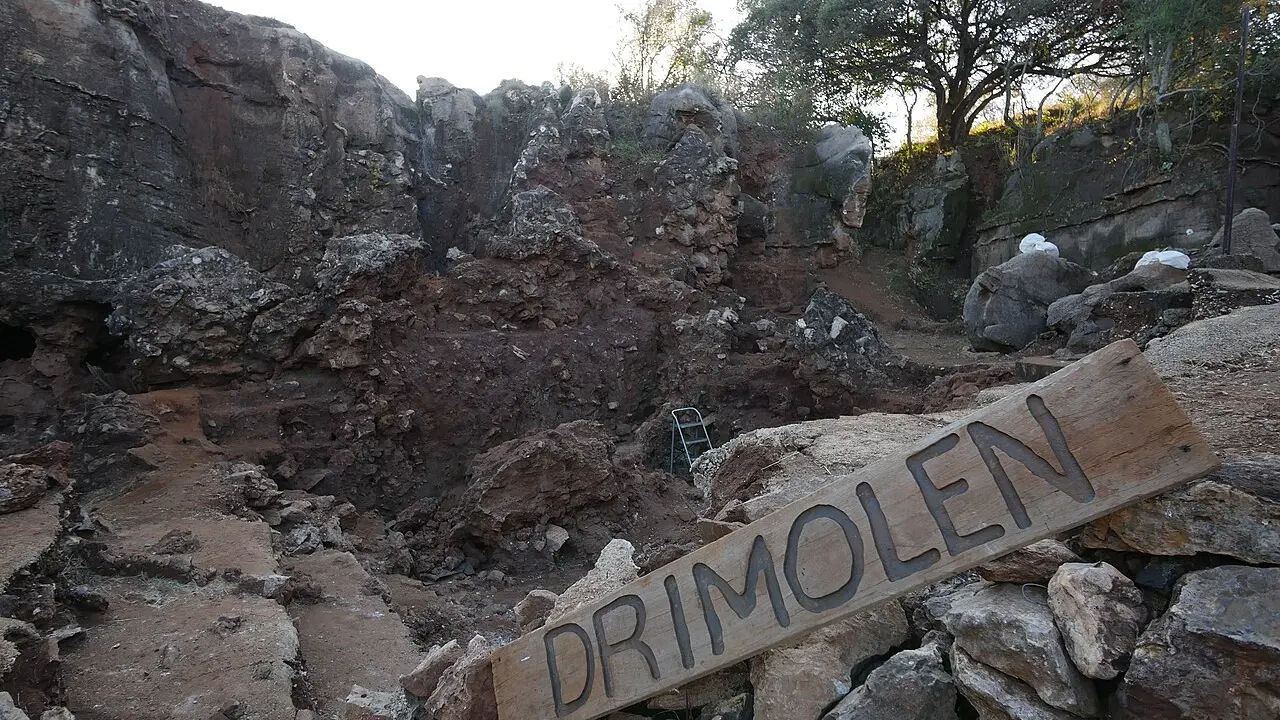 Breșă de peșteră cu sedimente expuse în carieră, locul unde au fost găsite fosile de hominin